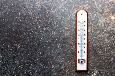 Wooden weather Thermometer on black background. Top view.