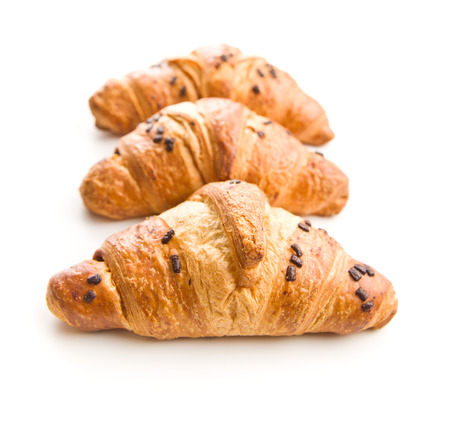 Three croissants with chocolate crumbs isolated on white background.の写真素材