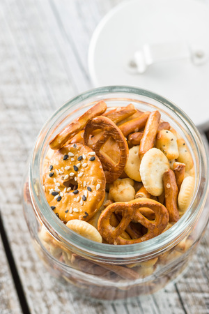 Mixed salty snack crackers and pretzels in jar.の写真素材