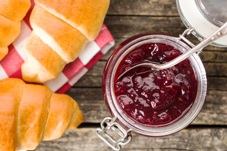 Raspberry jam jelly in jar and croissants. Top view.の写真素材