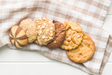 Different types of sweet cookies on checkered napkin.
