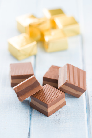 Sweet nougat pralines on blue table.の写真素材