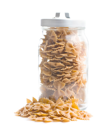 Wholewheat farfalle pasta. Tasty italian pasta in jar isolated on white background.の写真素材