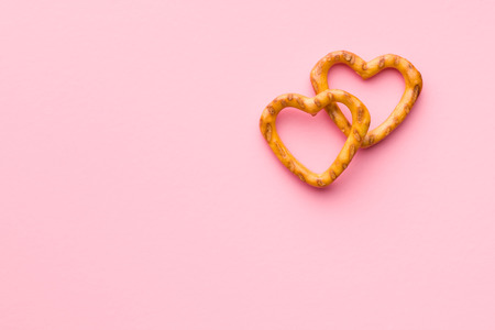 Heart shaped pretzel on pink background.の写真素材