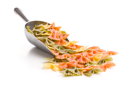 Farfalle pasta. Colorful italian pasta in scoop isolated on white background.の写真素材