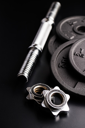 Dumbbell with black weight on black background.の写真素材