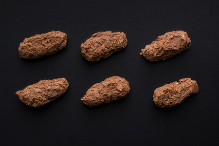 The chocolate pralines on black background.