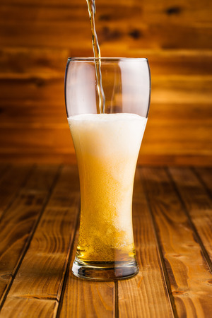 Glass of beer on wooden table.の写真素材