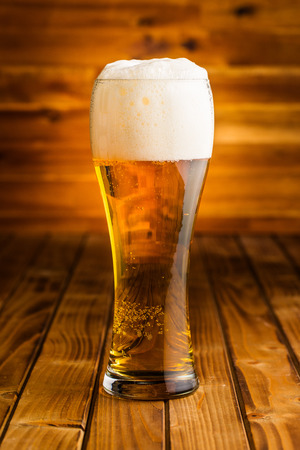 Glass of beer on wooden table.の写真素材