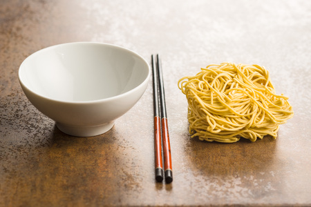 Uncooked instant chinese noodles and chopsticks.