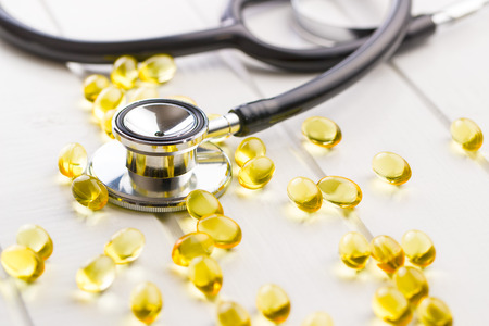 Omega 3 gel capsules and stethoscope.の写真素材