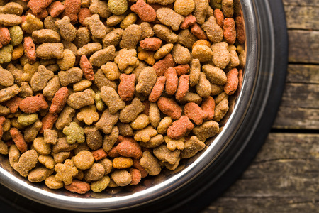Dry pet food. Dry kibble food in metal bowl. Top view.
