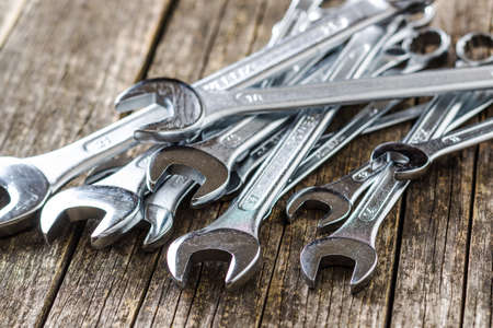 Chrome vanadium wrench. Industrial spanner on old wooden table.