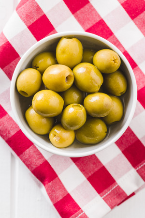 Marinated green olives in bowl. Top view.の写真素材