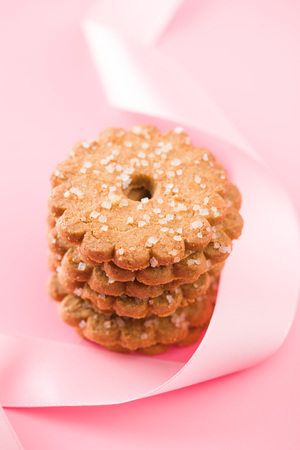 Christmas biscuits with sugar crystals on pink background.の写真素材