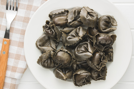 Squid ink tortellini pasta on plate. Top view.の写真素材