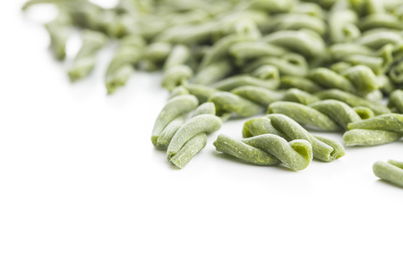 Uncooked spinach gemelli pasta isolated on white background.