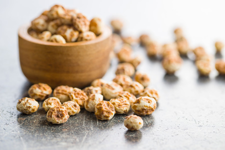 Tiger nuts. Tasty chufa nuts. Healthy superfood on old kitchen table.の写真素材