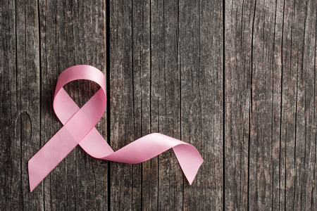 Pink breast cancer ribbon. Breast cancer symbol on old wooden table. Top view.の写真素材