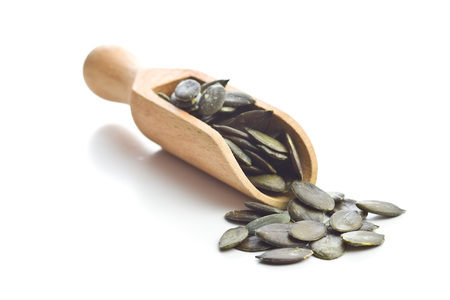 Peeled pumpkin seeds in scoop isolated on white background.の写真素材