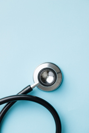 Black medical stethoscope on blue background.の写真素材