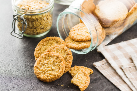 Crispy oatmeal cookies on black kitchen table.