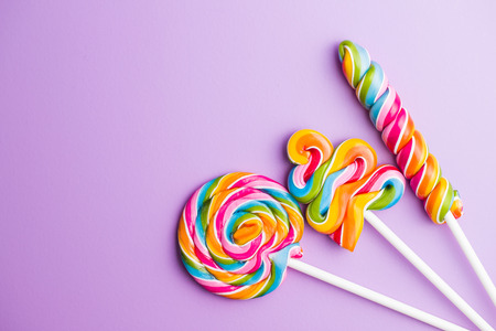 Various colorful lollipops on violet background.