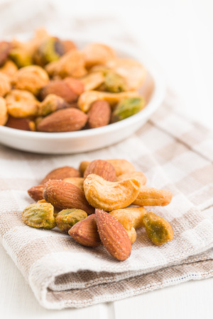 Spicy flavoured nuts. Mix of nuts in checkered napkin.の写真素材