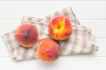 Sweet peaches fruit on checkered napkin.の写真素材