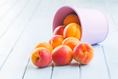 Sweet apricot fruits on blue wooden table.の写真素材