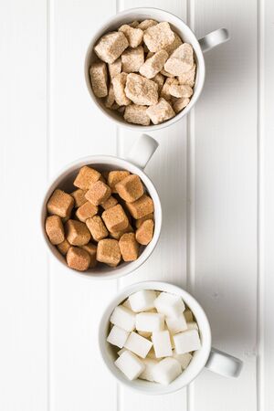White and brown sugar cubes in coffee mug. Top view.の写真素材