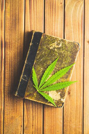 Marijuana cannabis leaf on old book. Top view.の写真素材