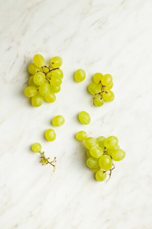 Tasty green grapes. White grape on white table. Top view.