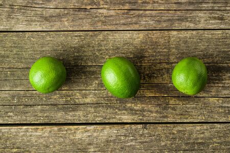 The green limes on old wooden table.の写真素材