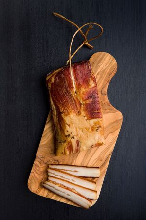 Smoked meat. Tasty bacon on black table. Top view.の写真素材