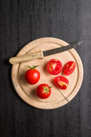 Sliced red tomatoes on black table. Top view.の写真素材
