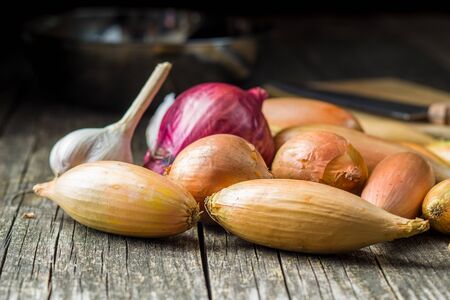 The golden shallot onion and garlic. Fresh bulbs on old wooden table.の写真素材