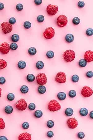 Blueberries and raspberries. Tasty mix of berries on pink background.の写真素材