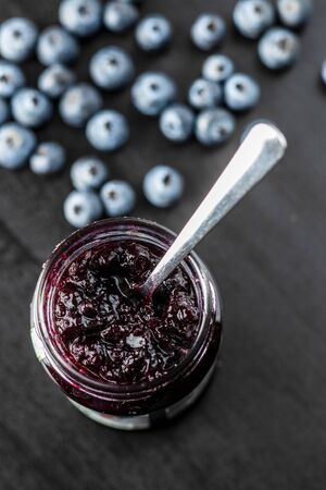 Sweet blueberry jam and blueberries on black table.の写真素材