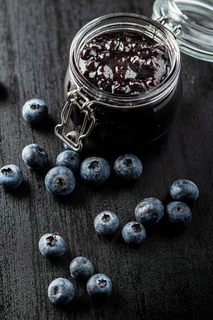 Sweet blueberry jam and blueberries on black table.の写真素材