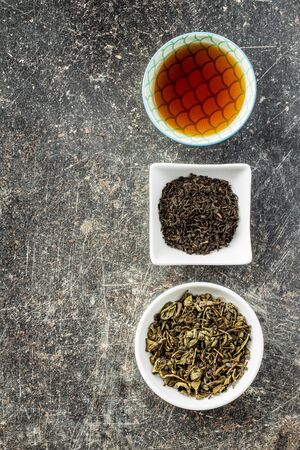 Dried black and green tea leaves in bowl. Top view.の写真素材