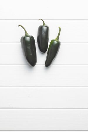 Green jalapeno peppers on white table. Top view.の写真素材