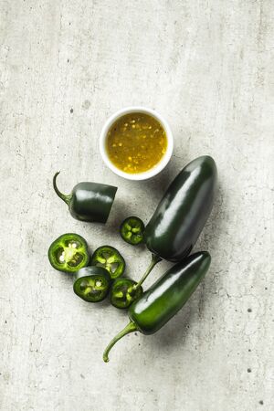 Sliced green jalapeno pepper and tabasco sauce. Top view.の写真素材