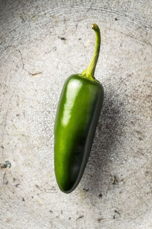 Green jalapeno pepper on old kitchen table. Top view.の写真素材