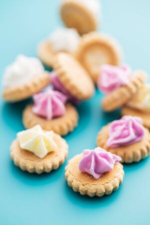 Sweet mini dessert cookies on blue background.の写真素材