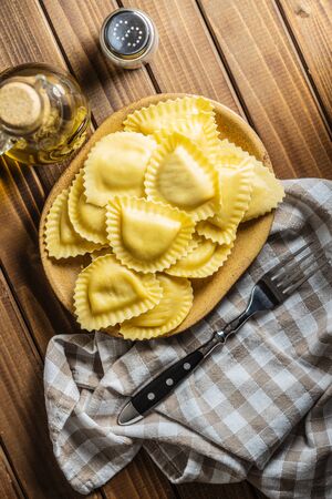 Italian stuffed pasta. Panzerotti pasta in bowl on old kitchen table. Flat lay.の写真素材