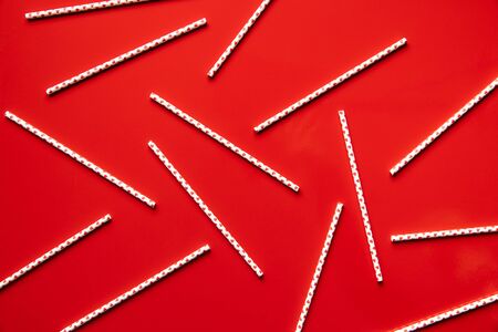 Paper straws with hearts on red background.の写真素材