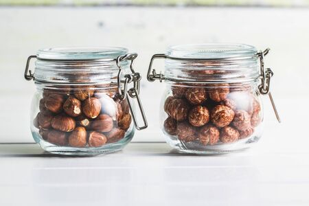 Hazelnuts with sugar icing in jar on white table.の写真素材
