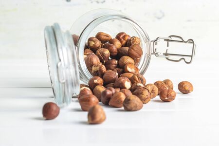 Dried hazelnuts in jar on white table.の写真素材