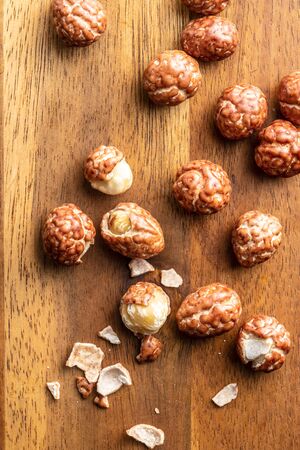 Hazelnuts with sugar icing on wooden table. Top view.